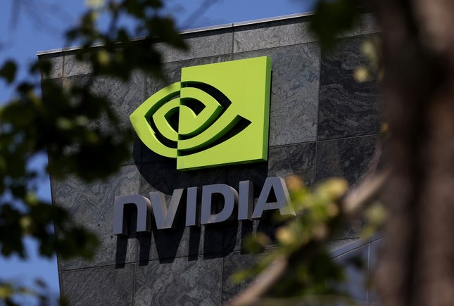 close up of Nvidia logo on building, blurry branches are in the foreground surrounding the logo